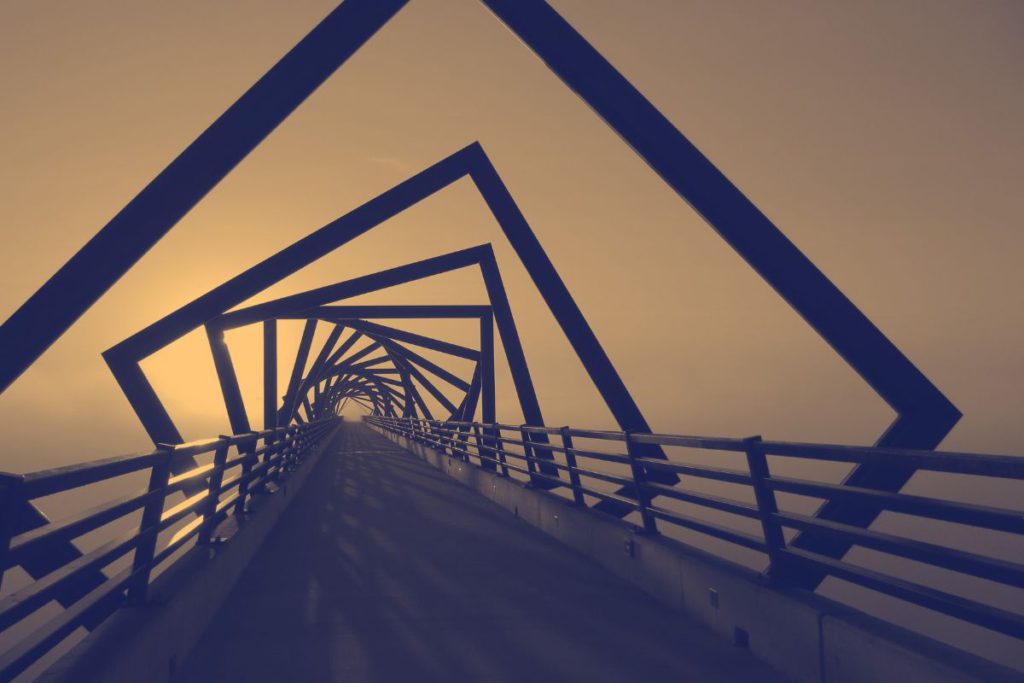 stylized two-tone photo of a walkway through a vortex of rotated square frames symbolizing the metadata journey.